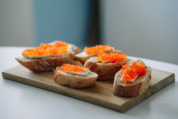 Salmon roe on bread. Slices of bread with red salmon caviar on a wooden board