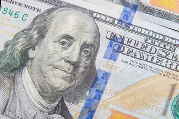 Obraz na płótnie Canvas One hundred dollar bills slices on the table close-up.