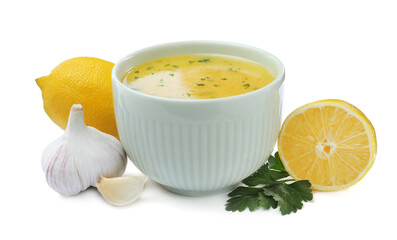 Bowl with lemon sauce and ingredients on white background. Delicious salad dressing