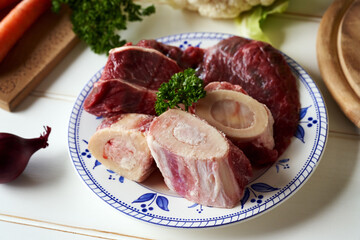 Marrow bones and vegetables - Ingredients for preparing beef bone broth or soup