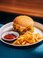 Hamburger, french fries and tomato ketchup on white plate