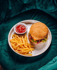 Hamburger, french fries and tomato ketchup on white plate. Top view
