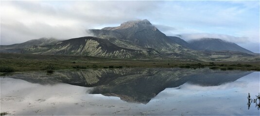 Panorama con montagne riflesse in acqua. Effetto specchio in un lago Islandese.