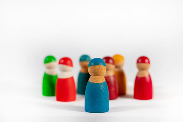 leadership design with group of wooden carved human figures in different colors like red, blue green on white background