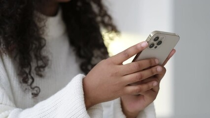 African American Girl using iPhone 12 smartphone pressing finger, reading social media internet, typing text or shopping online Mobile phone in two black hands 13.12.21 St.Petersburg Russia.
