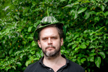 Portrait of a farmer man with a mature juicy pattison on his head	
