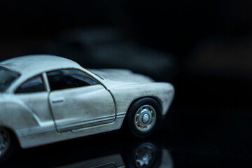 a model of an old classic shabby car on a glossy black glass background