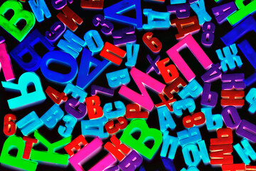 Fototapeta premium Colorful alphabet letters on a magnet on black