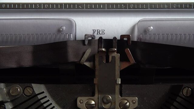 Typing word Free on a vintage typewriter. Close up.