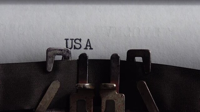 Typing abbreviation USA on a vintage typewriter. Close
