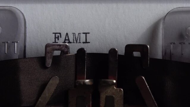 Typing word Family on an old typewriter. Close up.