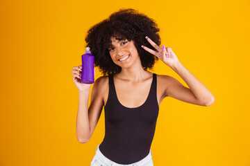 young afro woman holding in hands a package of hair cream
