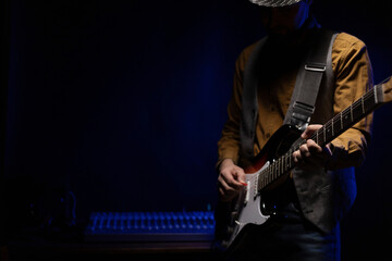Man playing electric guitar. Musician in studio holding electric guitar