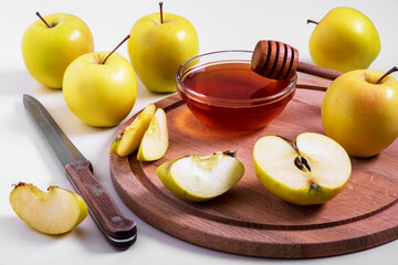 Fresh ripe whole and cut yellow apples with honey lie on table. Selective focus.