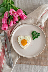Tasty Fried Egg in the Shape of a Heart Served on a White Plate with Green Peas Linen Tablecloth Valentine Day Breakfast