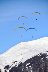 paragliding in the mountains over snowcapped mountains 