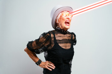 Happy senior lady shooting power energy rays from the eyes - obrazy, fototapety, plakaty