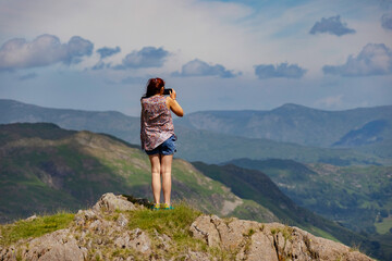 Naklejka premium a lady standing on top of a mountain with the camera