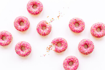 Bakery background of pink glazed donutes with sprinkles
