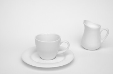 Obraz na płótnie Canvas white coffee cup and milk jug with milk on white background