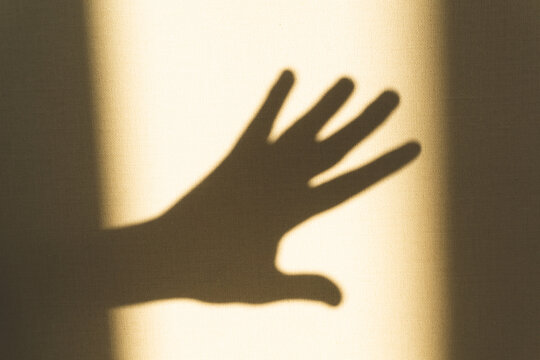 Shadow of hand showing gesture on the wall