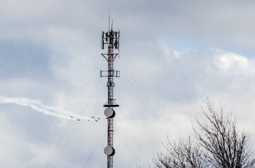 Obraz premium Jets flying in formation past a tall communications tower