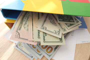 office folders close-up, american dollars banknotes, concept of filling out tax return, paying taxes, Corporate business income, expenses, maintaining household expenses, Gearing Up for Startups