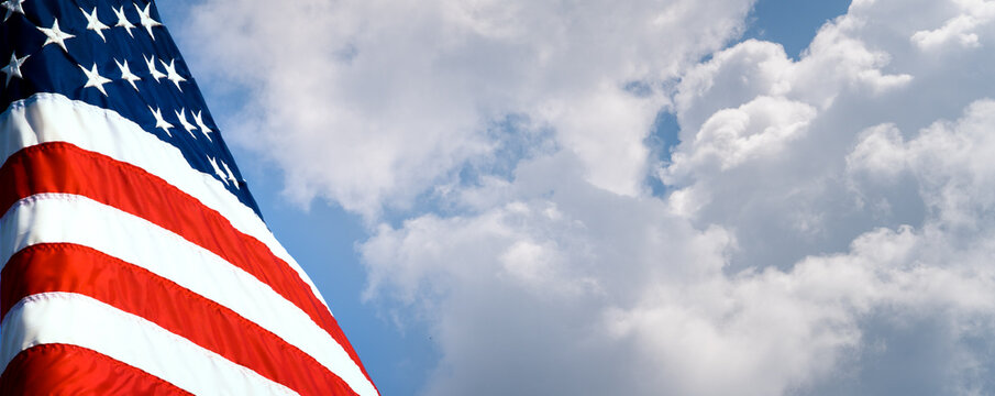 Patriotic United States of America flag at rest before a beautiful blue sky with room for text and cropping. Social media or web banner or header.	
