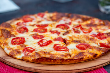 pizza margherita on a wooden plate close-up