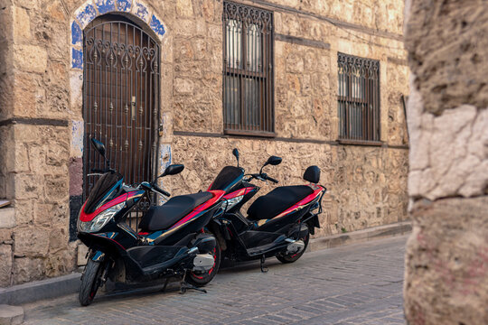 two motorcycles parked in a historic narrow lane
