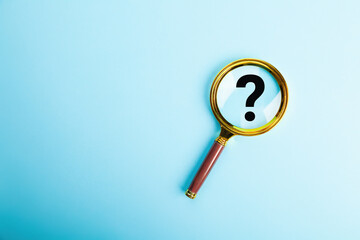 Magnifying glass with question mark symbol on blue background. The concept of creative idea and innovation, search and research.