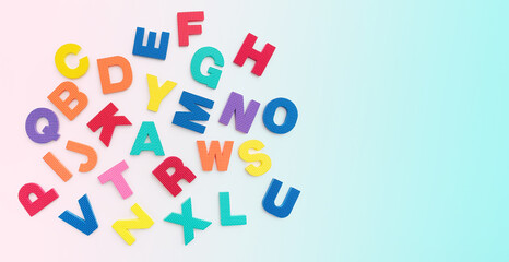 Letters of the alphabet placed on gradient pastel color or white background. Literacy concept. Writing and reading learning concept.