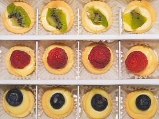 Mini cakes with berries and fruits. raspberry, blueberry and kiwi. delicious small tarts