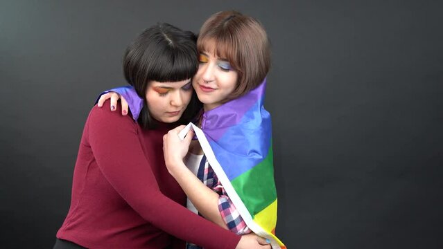 Lesbian couple, happy girl homosexual dancing and having Fun with flag symbolic expression LGBTQ flag.  