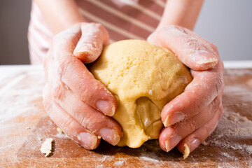 Wide angle of woman hand kneading of dough for pizza, cookies, bins or gingerbreads on the wooden desk. Home made pastry