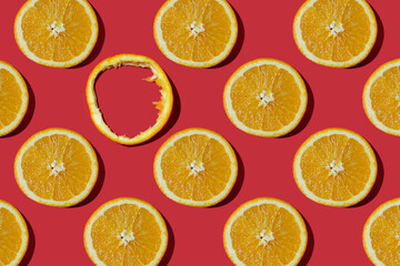 Summer composition made from oranges, on dark red  background. Creative Pattern made of slices of orange. Flat lay