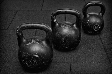 Naklejka na ściany i meble three black iron kettlebell for weight training black and white photography