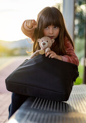 sitting girl talking and teaching her teddy bear