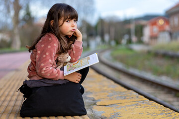 Fototapeta premium Bored girl waits for the arrival of the train