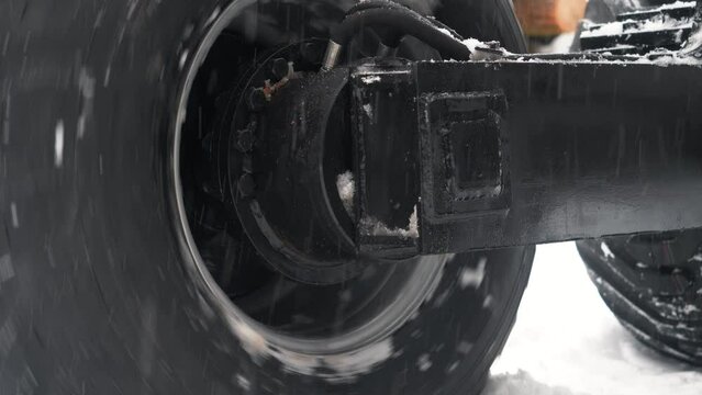 Tractor wheel slips in the snow close-up