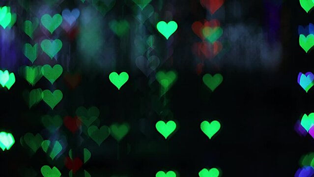 4K UHD video background for Valentine's Day. Border with bokeh of romantic shining and shimmering hearts on a black background. Love, bokeh in the shape of a heart. High quality 4k video.