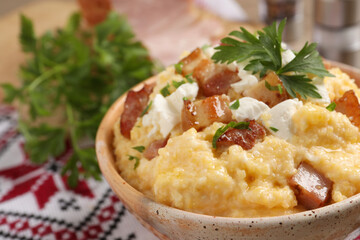 Delicious traditional Ukrainian banosh in bowl on table, closeup