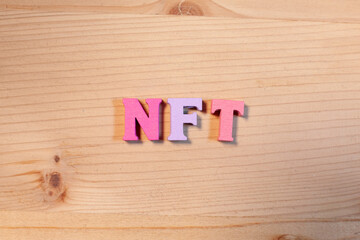 nft letters on wooden background