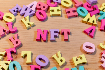 nft letters on light wooden background