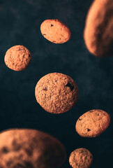 Floating chocolate cookies with dark background.