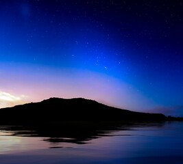 Fototapeta na wymiar Starry Skies over Coastline Silhouette