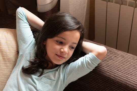 Happy smiling girl lying on the couch in her home