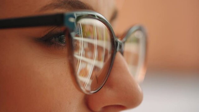 Close up view into the eye of a computer hacker as he monitors a computer screen. Female using internet, reading, watching, styding, analizing, working online late.