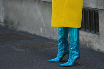 woman wearing neon blue high heel boots and yellow coat