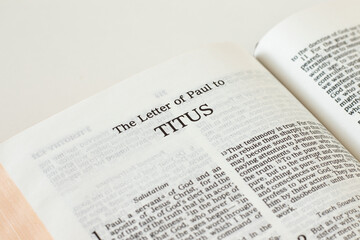 Titus letter open Holy Bible Book isolated on white background. New Testament Scripture. Studying the gospel of God Jesus Christ. Christian biblical concept of love, faith, trust. A close-up.